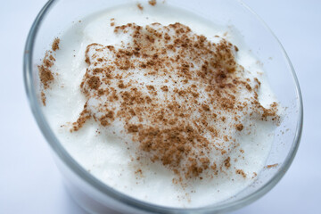 Glass of aroma latte with milk foam and cinnamon powder