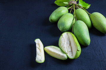 Fresh green mango fruit on a wooden table