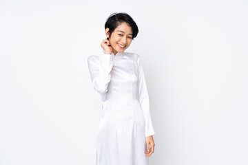 Young Vietnamese woman with short hair wearing a traditional dress over isolated white background laughing