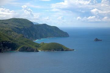 Spectacular panoramic view of Palaiokastritsa village and beach with its harbor during the midday on. Corfu, Greece.