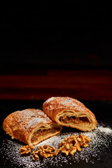 Freshly made walnut filled puffed pastry on black stone. Very shallow depth of filed.