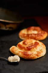 Freshly made pastry burek on black stone cutting board. Very shallow depth of field