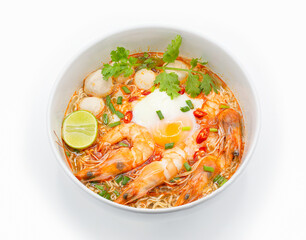 Tom yum kung or hot and spicy shrimp soup boiled with noodle and ingredient inside, in the white bowl.