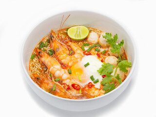 Tom yum kung or hot and spicy shrimp soup boiled with noodle and ingredient inside, in the white bowl.