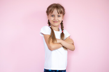 Beautiful little blonde girl with long hair in white T-shirt smiling on a pink background