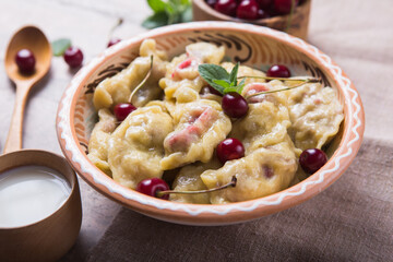 Preparing dumplings with cherry. making pierogi or pyrohy, varenyky. Traditional Russian cuisine, or  Ukrainian hand-made vareniki