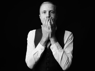 Businessman with blond hair against black background in black and white