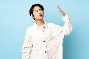 Young Vietnamese woman with short hair over isolated background with tired and sick expression