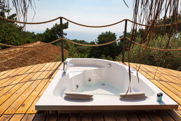 Hot tub in the room balcony with sea view. Luxury honeymoon romantic vacation place.