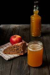 Kvass drink in a glass jar on an old wooden board with rye bread 
