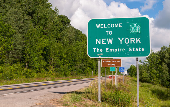The Welcome to New York state line sign on US Route 62 in Chautauqua County, New York, USA on a sunny summer day