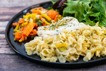 cod fish with vegetables, small vegetables and marine sauce