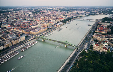 Fototapeta na wymiar Aerial view of the Liberty Bridge by Danube river in Budapest, Hungary. Gathered people during summer evening. The Freedom Bridge is closed for motorised vehicles and open for pedestrians only.