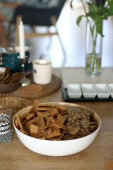 Two types of seed crackers, served in a big bowl on a table. Selective focus.
