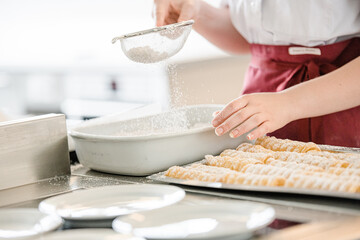Powder of sugar is hung on a Pieces of Christmas chocolate cake on wooden background.