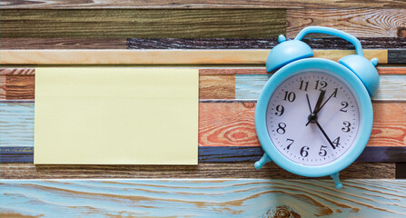 Alarm clock with sticky paper on striped background