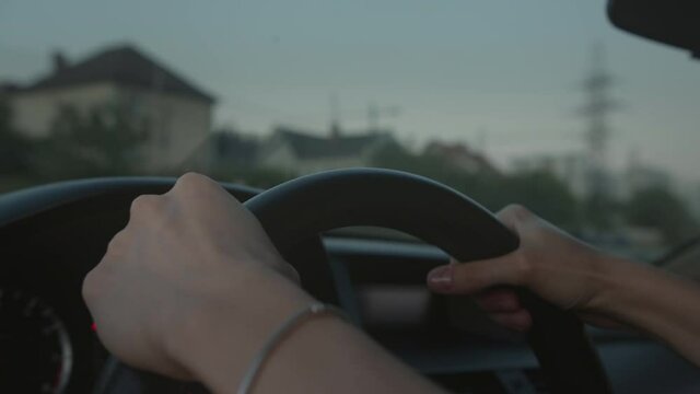Female hands on a steering wheel