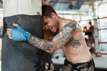 Training in the gym in the ring with a muay thai trainer. Tattooed caucasian man and Asian trainer....