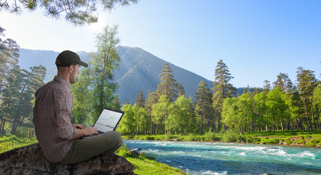 man working remotely outdoors with laptop