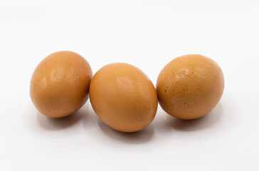 Three brown chicken's eggs isolated on white background.