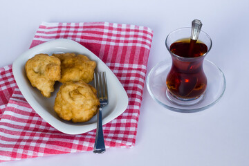 Traditional Turkish Deep Fried Dough on fabric napkin with tea.Top view