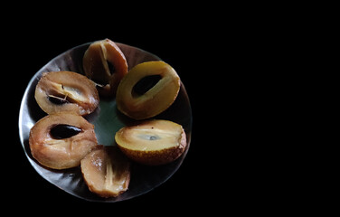 Half-cut chikoo Sapodilla in a steel plate