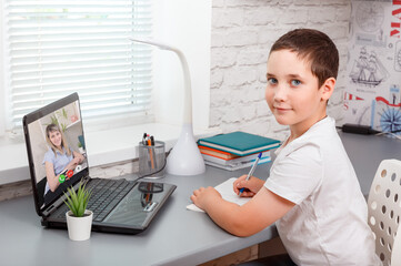 Child attending to online school class. Online child education at home