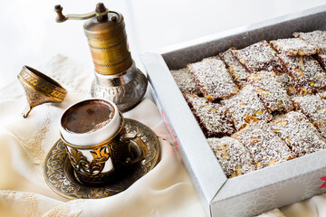 Box of traditional turkish dessert cezerye and Turkish coffee with coffee grinder. Festival of sacrifices. Feast of Ramadan. Cezerye is made with boiled carrots, sugar, pistachio and coconut. 