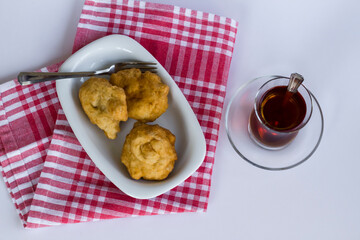 Traditional Turkish Deep Fried Dough on fabric napkin with tea.Top view