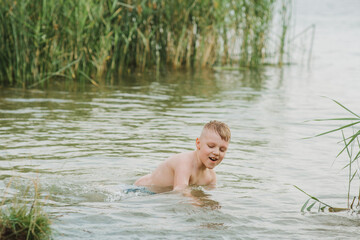 Fototapeta premium Happy boy swimmimg in the lake . Summer Holidays
