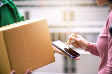 Housewife woman sign a package from a sender on a smartphone in the digital age, responding to the...