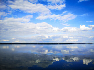 Clouds on a blue sky with reflection in water