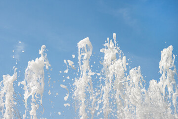 Blue sky background with refreshing flowing fountain water spray pattern macro wallpaper