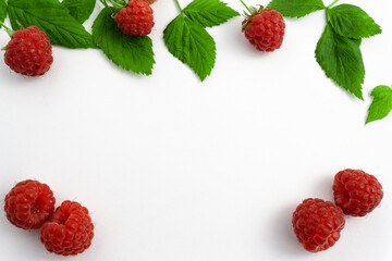 Ripe raspberries isolated on white background close-up. Beautiful red fresh raspberries with leaves along the contour on the table. Top view. Banner for the site. Free space for text in the center
