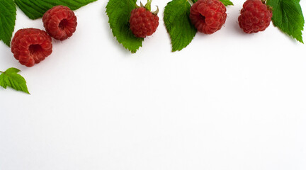 Ripe raspberries isolated on white background close-up. Beautiful red fresh raspberries with leaves along the contour on the table. Top view. Banner for web site. Free space for text