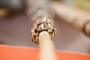 hands of the elderly craftsman while weaving a wicker basket at the market