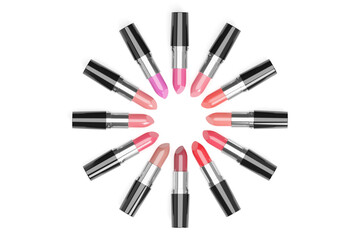 Lipsticks of different colors arranged in a circle on white background.