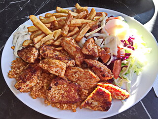 Chicken meat with french fries and fresh vegetables. 