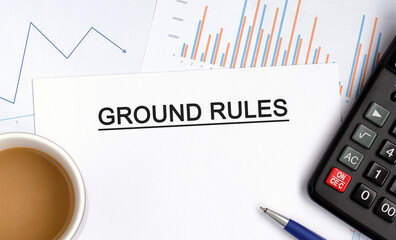 Ground rules document with graphs, diagrams and calculator and a cup of fragrant coffee