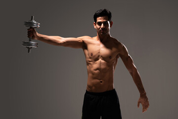 Fototapeta na wymiar Muscular Latin Man Exercising In Studio