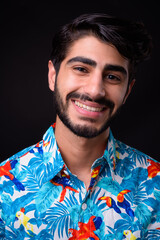 Young handsome bearded Persian tourist man ready for vacation against black background