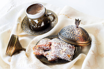 Turkish coffee with traditional turkish dessert cezerye and copper serving set. Festival of sacrifices. Feast of Ramadan. Cezerye is made with boiled carrots, sugar, pistachio and coconut. 