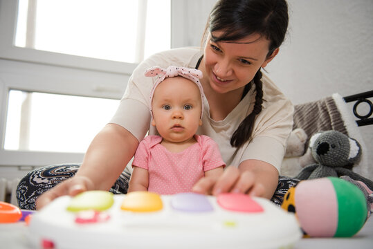 The adorable baby looks at the camera while her mother watches over her