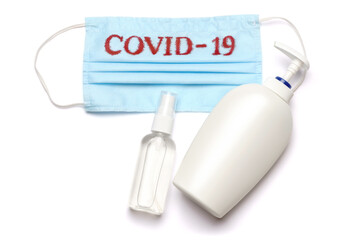 bottle of lotion, sanitizer or liquid soap and medical protective mask with COVID-19 sign isolated on white background with clipping path