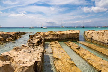 View of a series of hand made canals carved in the rock in Formentera island, Spain. beautiful turquoise sea.