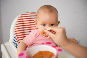 Adorable baby girl eating her porridge