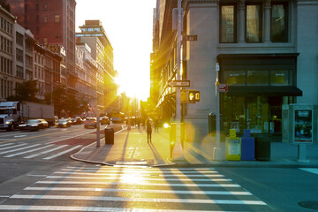 Sunset on the corner of 23rd Street and 5th Avenue with people and cars in Manhattan, New York City