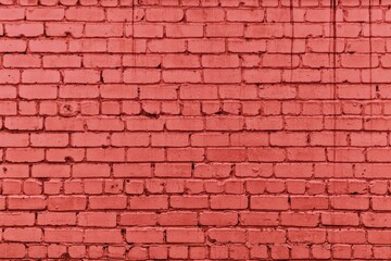 Bright coral color painted old grungy brick wall texture. Red rough brickwork. Abstract masonry grunge industrial background