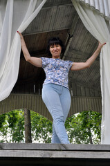 Portrait of a beautiful European woman resting in a gazebo by the lake.