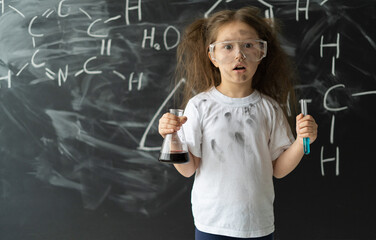 Little girl makes experiments in chemistry lesson. Explosion during the experiment.